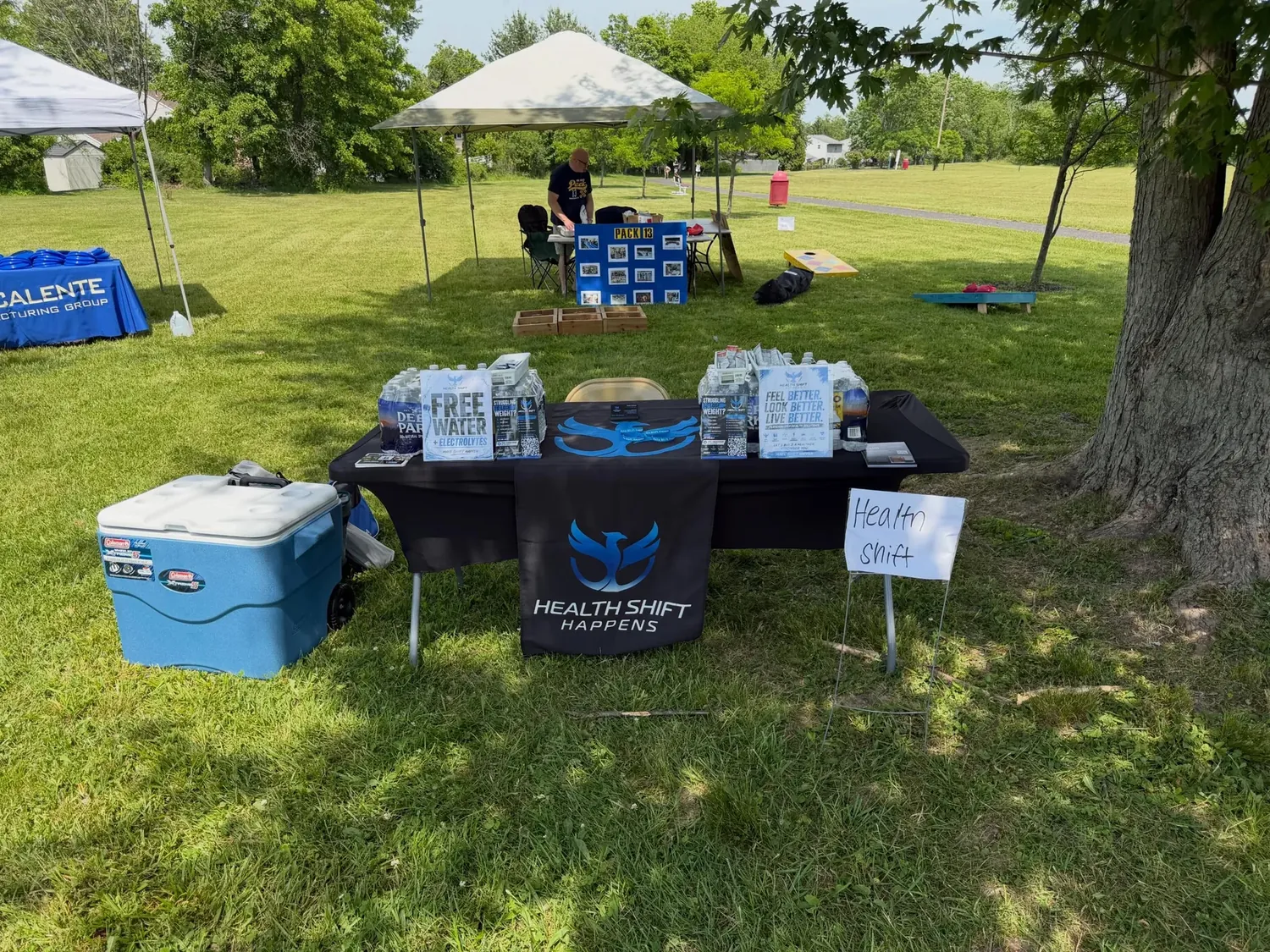 Health Shift Happens booth at a community event, with a phoenix banner and free water